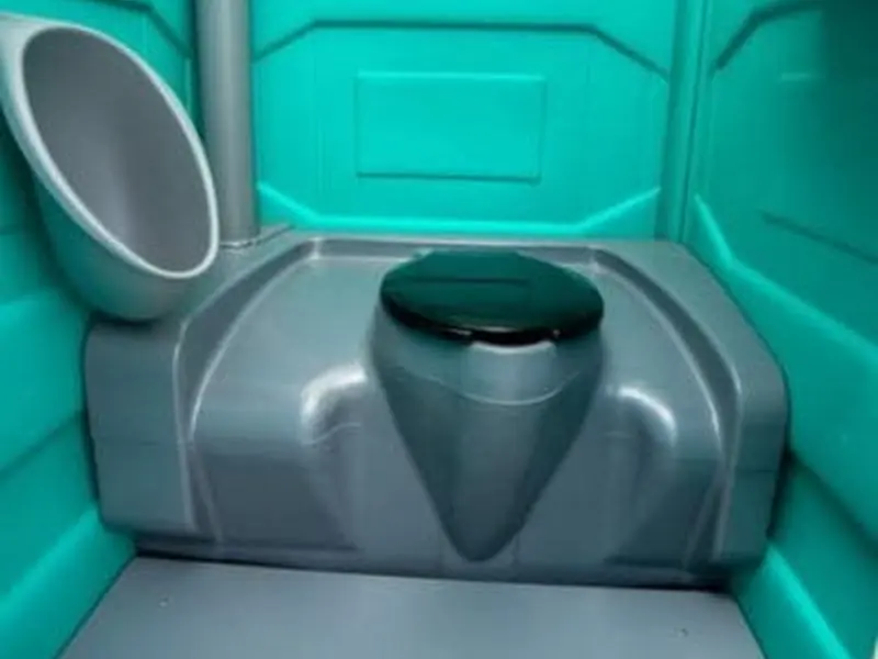 Inside a freshly serviced portable restroom showing a clean seat, fresh water in the bowl and wiped walls