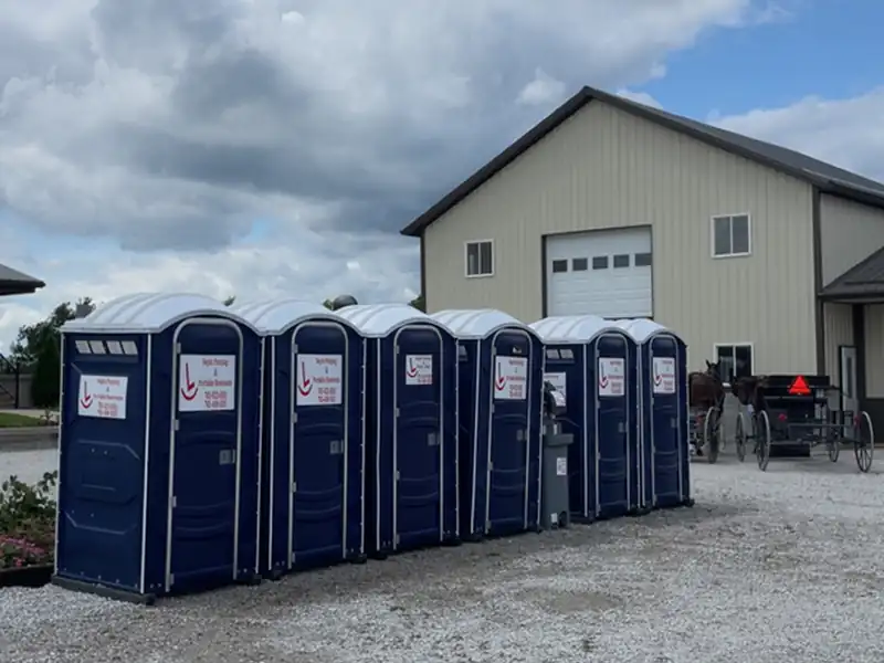 The Rockin L fleet of blue portable restrooms lined up on the gravel yard beside the shop building in Bloomingdale, Indiana