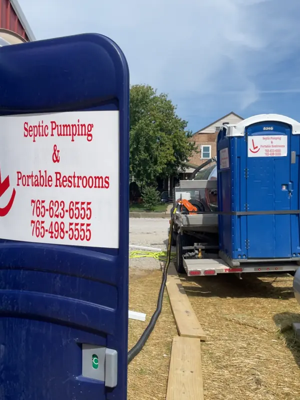 Close view of the Rockin L decal on a blue portable restroom reading Septic Pumping and Portable Restrooms with the phone number