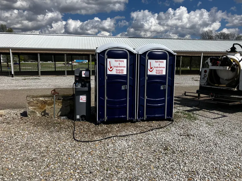 Two Rockin L restrooms with a freestanding handwash station beside a covered pavilion